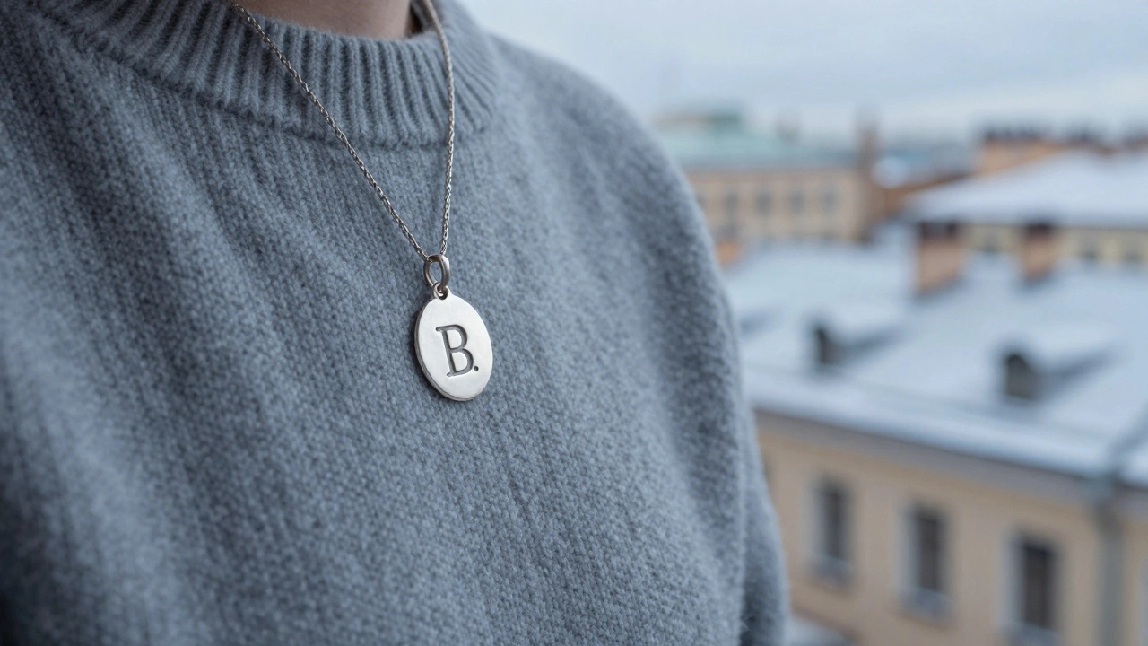 Серебряный кулон с инициалами на свитере у окна в Санкт-Петербурге